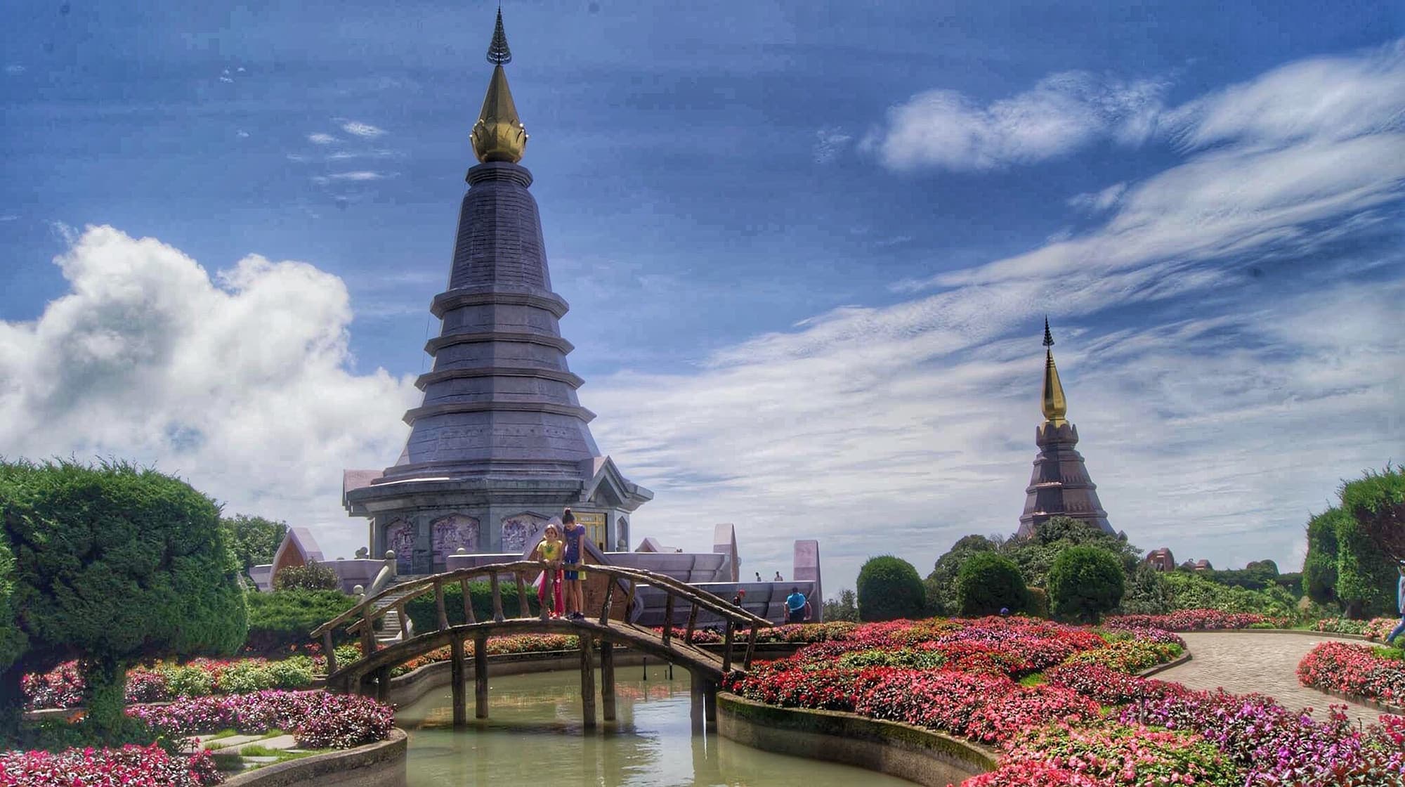Royal pagoda of Doi Inthanon behind a bridge and flower beds