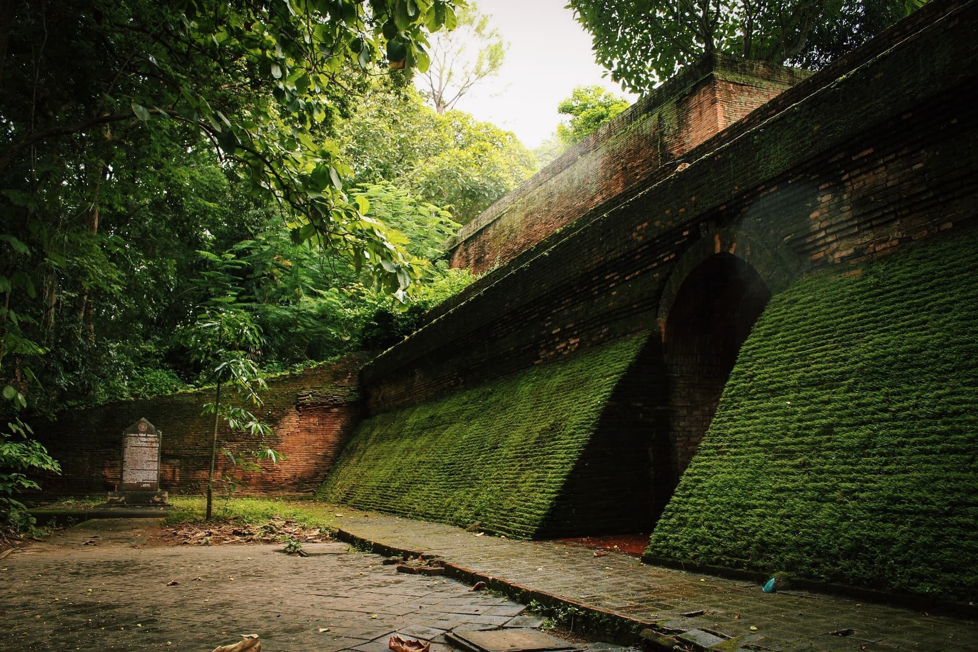 Moss-covered walls above the tunnel entrances of Wat Umong