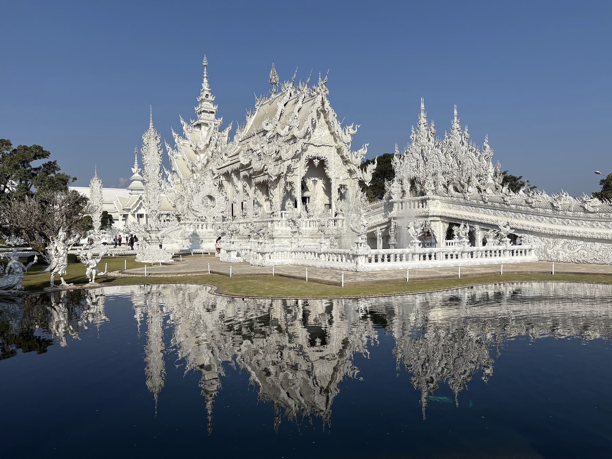 Wat Rong Khun, the White Temple of Chiang Rai, reflected in its pond